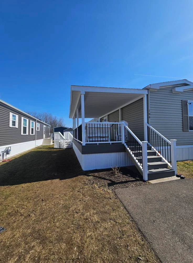 Compact covered front porch with white posts, aluminum railings and stairs