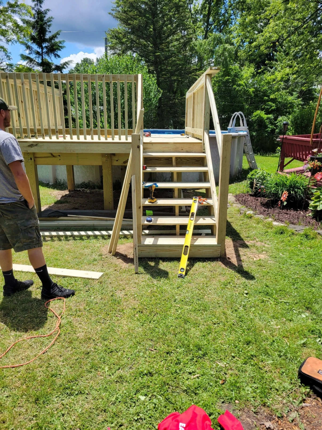 Pool side deck and staircase build in progress with pressure treated framing and railings