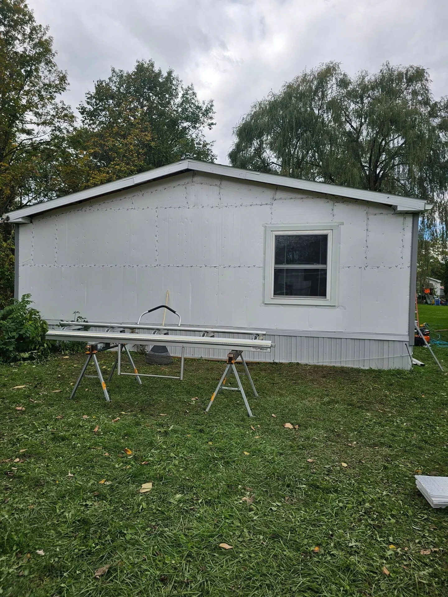 Manufactured home wall fully prepped with foam board insulation, ready for new siding